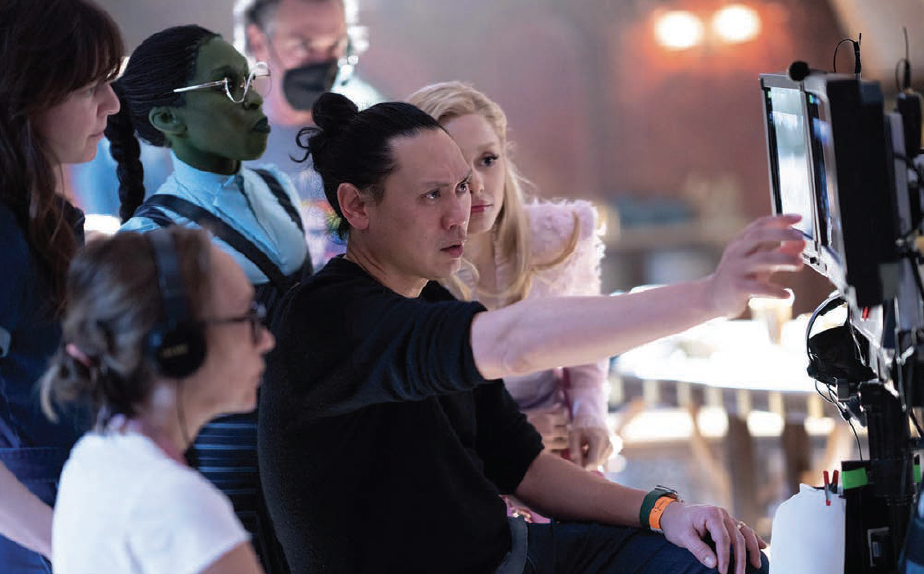 Absent in Kansas: Director John Chu plays with Erivo, Ariana Grande and the crew. 